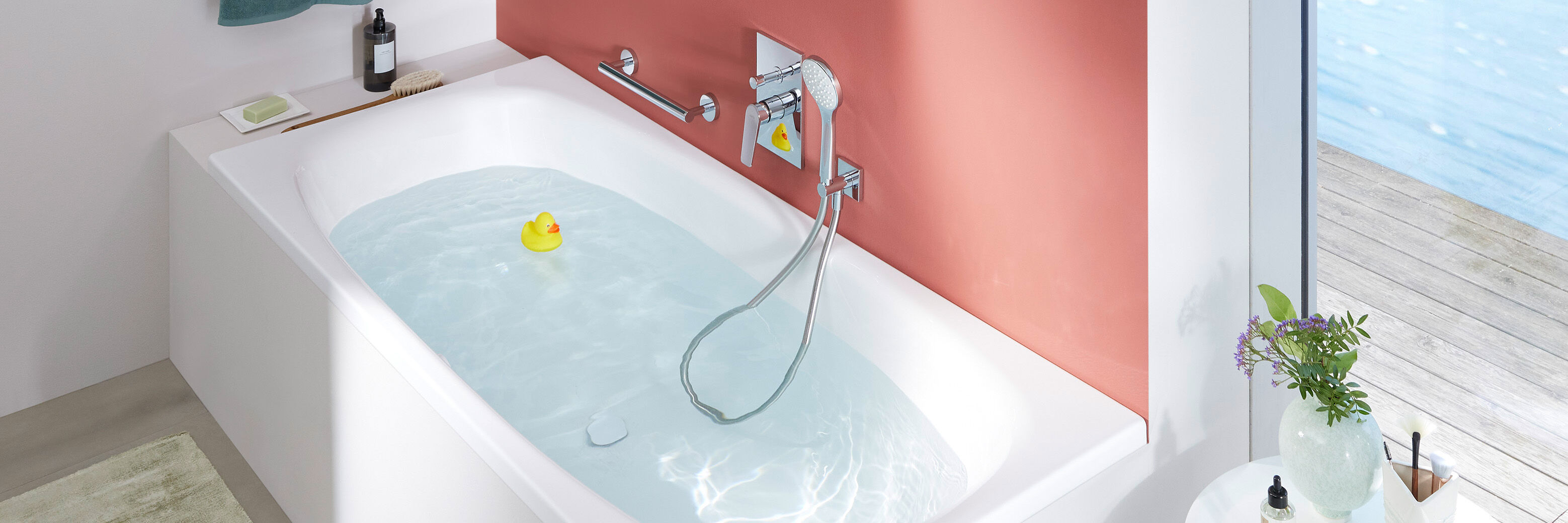 eckige badewanne mit wasser gef&uuml;llt. armatur und haltegriffe seitlich aus chromstahl