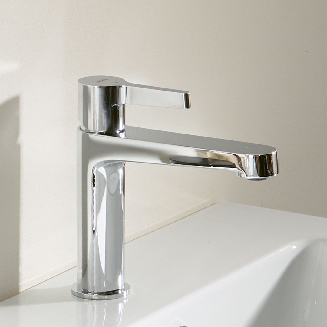 moderne verchromte badarmatur vor beiger wand