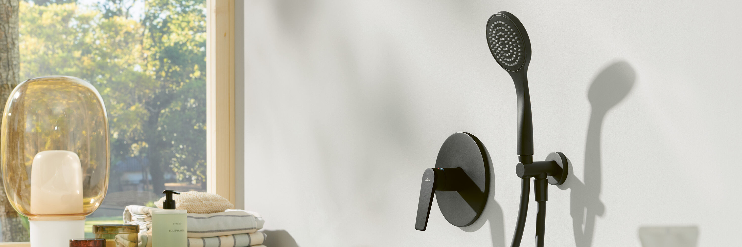 schwarze badewannenarmatur und moderne glasleuchte und seife