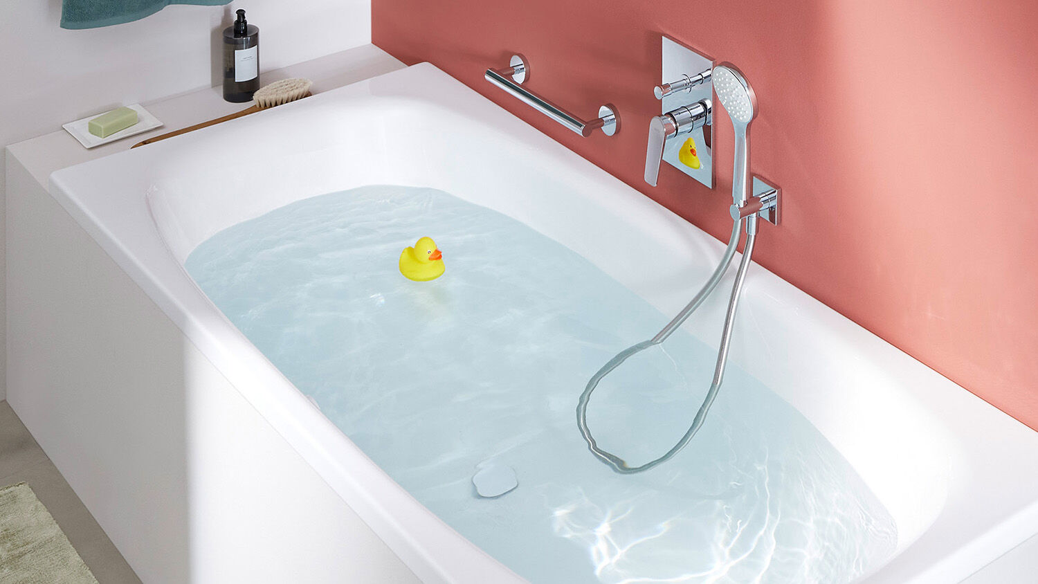 badewanne mit wasser gef&uuml;llt und gelber badeente, seitlich verchromte badarmatur und haltegriff