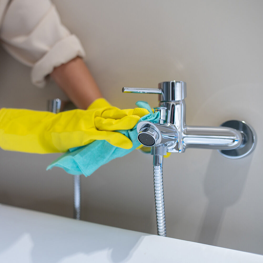 armatur verchromt badezimmer wird geputzt gelbe handschuhe